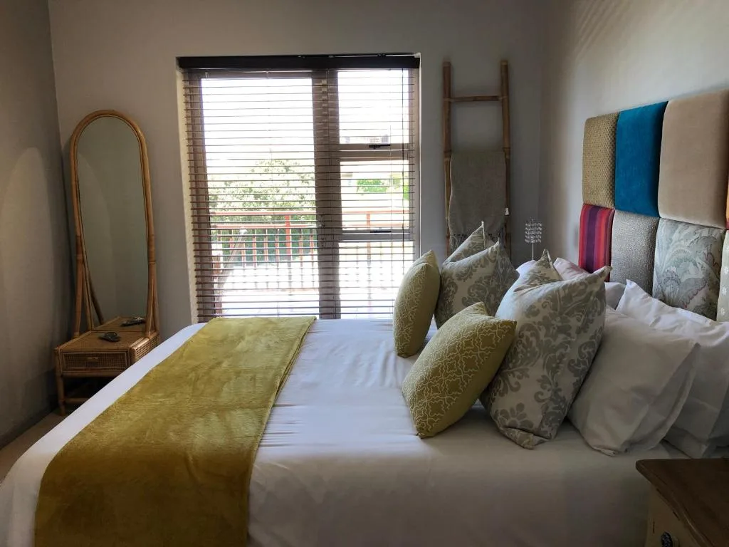 Bright bedroom with queen bed, decorative pillows, and sliding doors opening to views