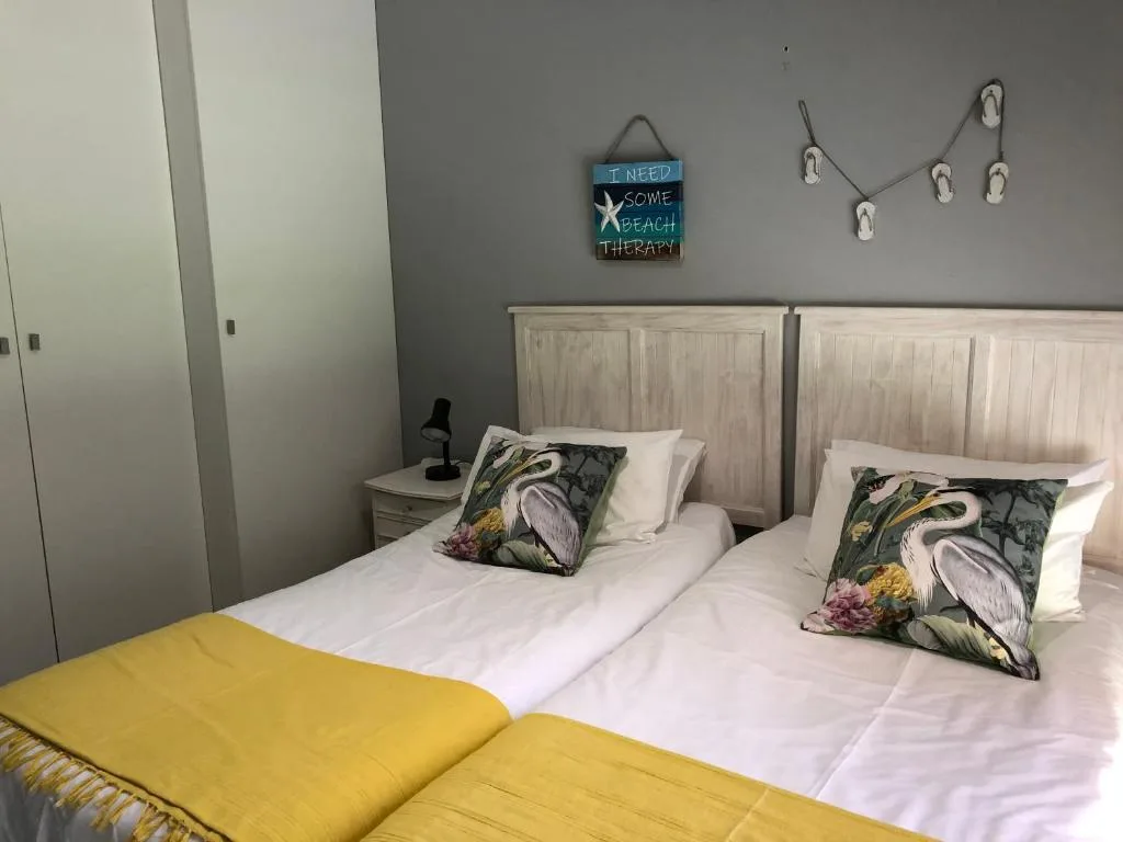 Twin beds with coastal-themed pillows and beach therapy wall decor
