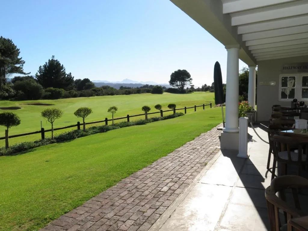 Covered patio with mountain views overlooking manicured gardens and rolling countryside