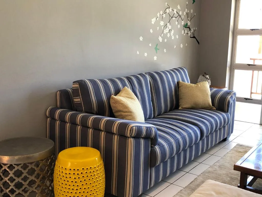 Striped sofa with yellow cushions and decorative hanging flowers