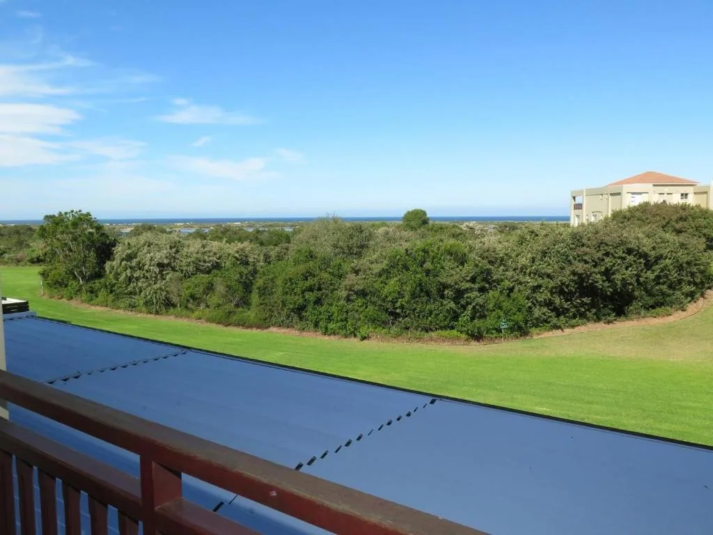 Ocean and mountain vista from deck overlooking manicured gardens and native vegetation