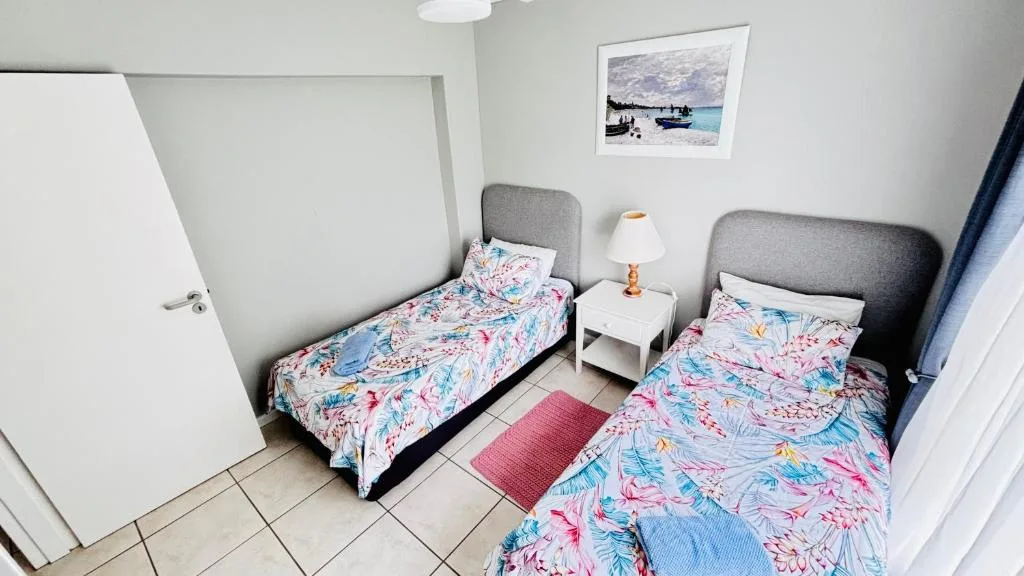 Twin bedroom with colorful floral bedding and bedside lamp