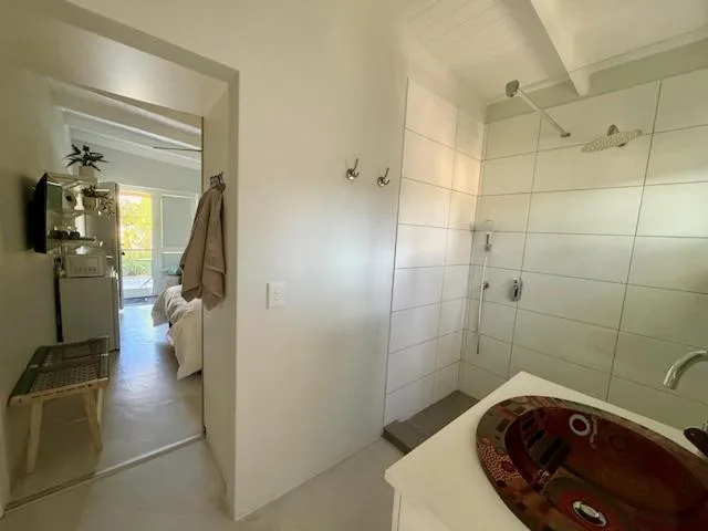 Modern bathroom with walk-in shower, red soaking tub, and neutral tiling