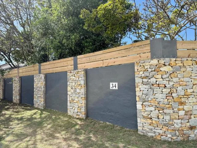 Modern stone and timber garage entrance with dark metal gates