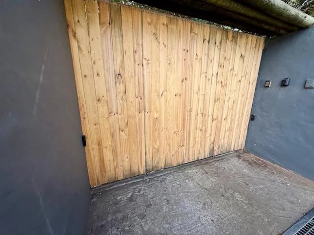 Wooden garage doors and gray exterior wall of modern accommodation building
