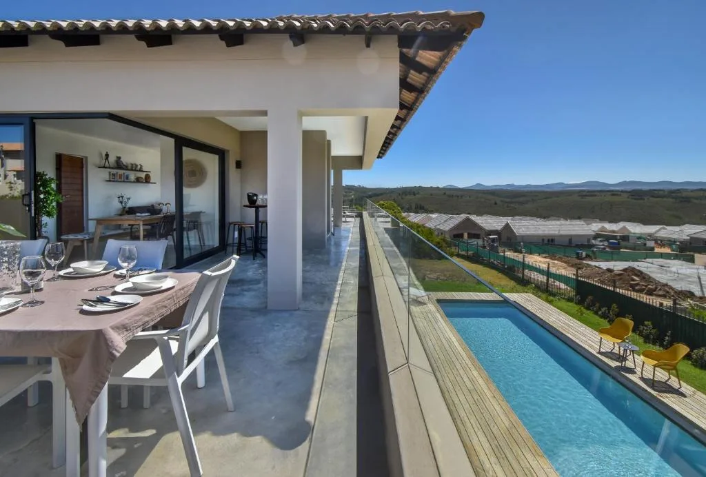 Outdoor dining area with pool and mountain valley views beyond