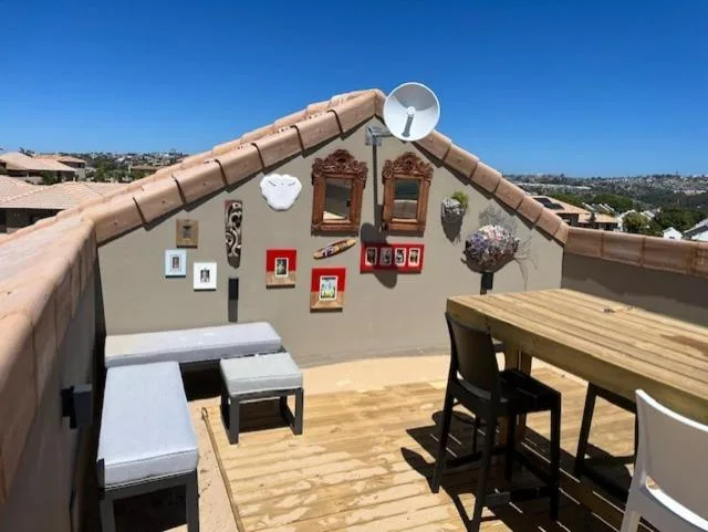 Rooftop deck with wooden flooring, dining table, and mountain views