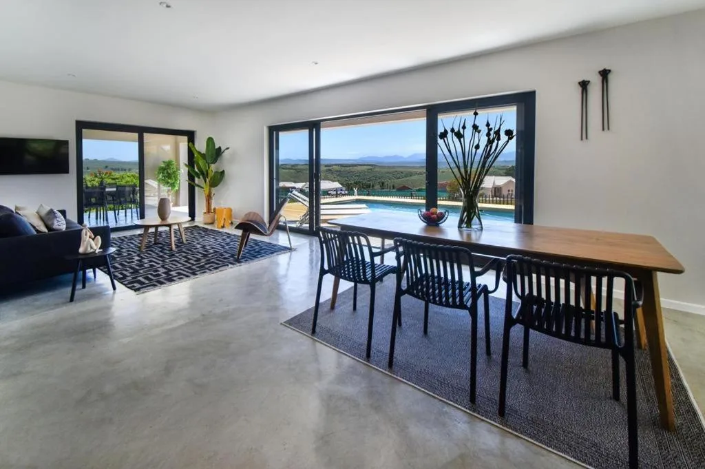 Open-plan living and dining area with pool views through large windows