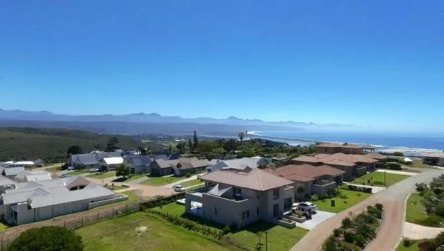 Aerial view of property with mountains and ocean coastline beyond