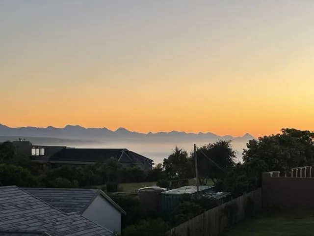 Sunset view of mountains and ocean from property overlooking Plettenberg Bay