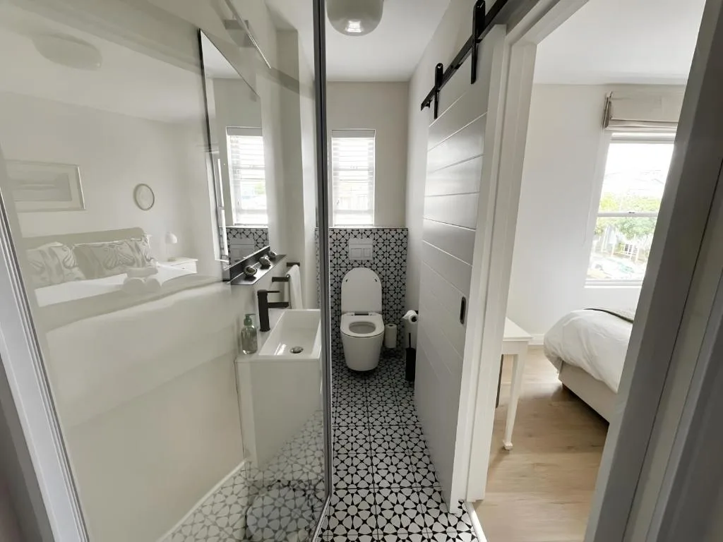 Modern ensuite bathroom with black geometric tile flooring and white vanity
