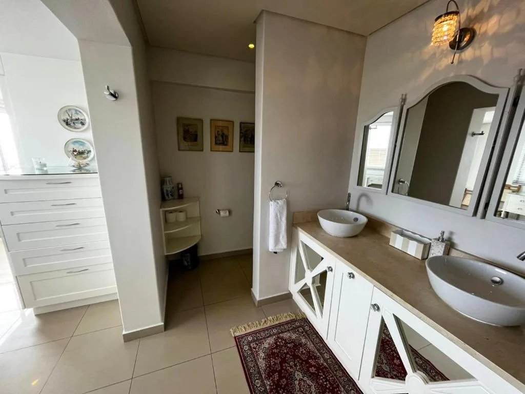 Spacious bathroom with dual white vessel sinks and large mirror