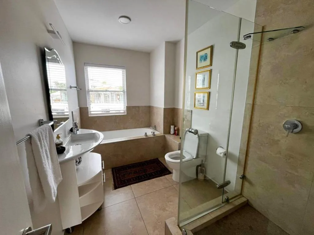 Modern bathroom with bathtub, shower enclosure, sink, and toilet facilities