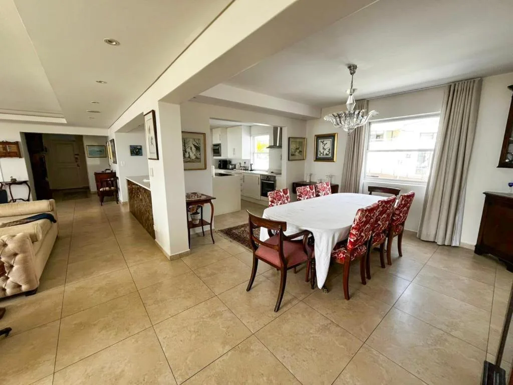 Elegant dining area with white-clothed table and red patterned chairs
