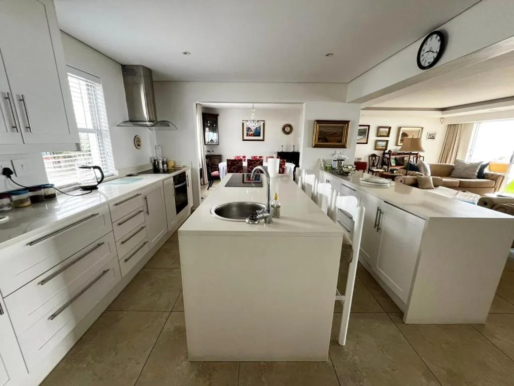 Modern white kitchen with island sink and stainless steel appliances