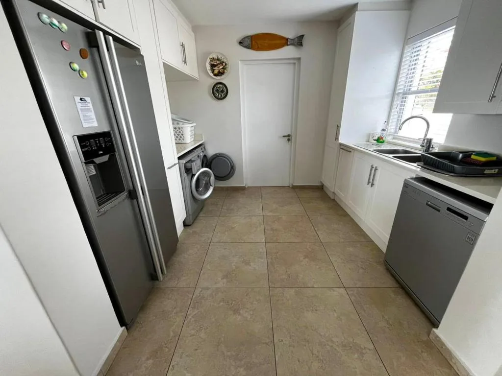 Modern kitchen with stainless steel appliances and white cabinetry throughout