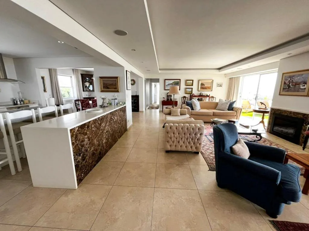 Open-plan lounge with cream sofas, fireplace, and contemporary furnishings