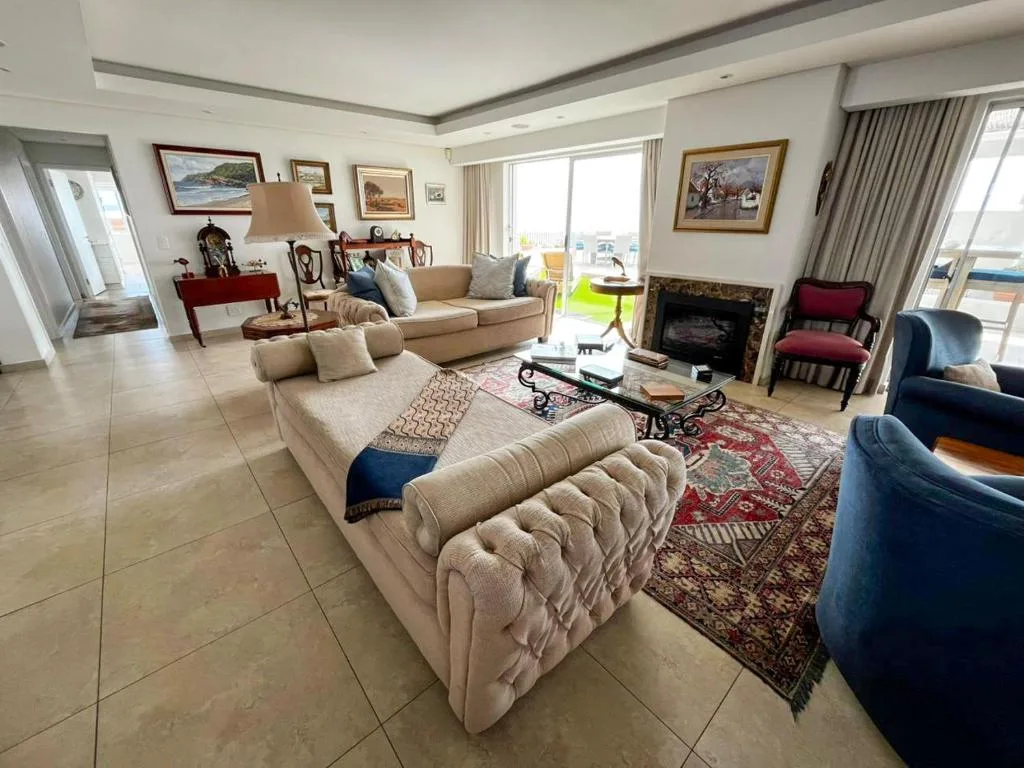 Spacious penthouse lounge with comfortable seating, fireplace, and panoramic windows