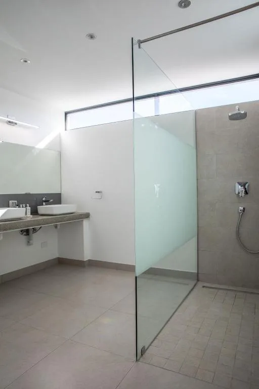 Modern bathroom with walk-in shower, vanity basin, and overhead rainfall showerhead