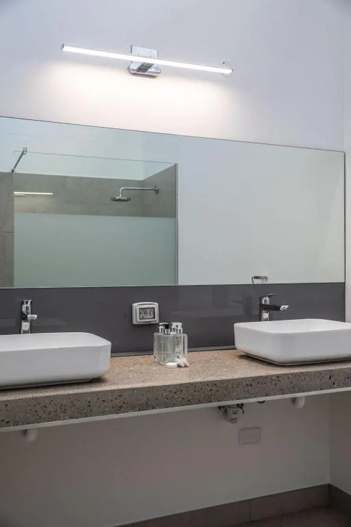 Modern bathroom with dual vessel sinks and large mirror with lighting