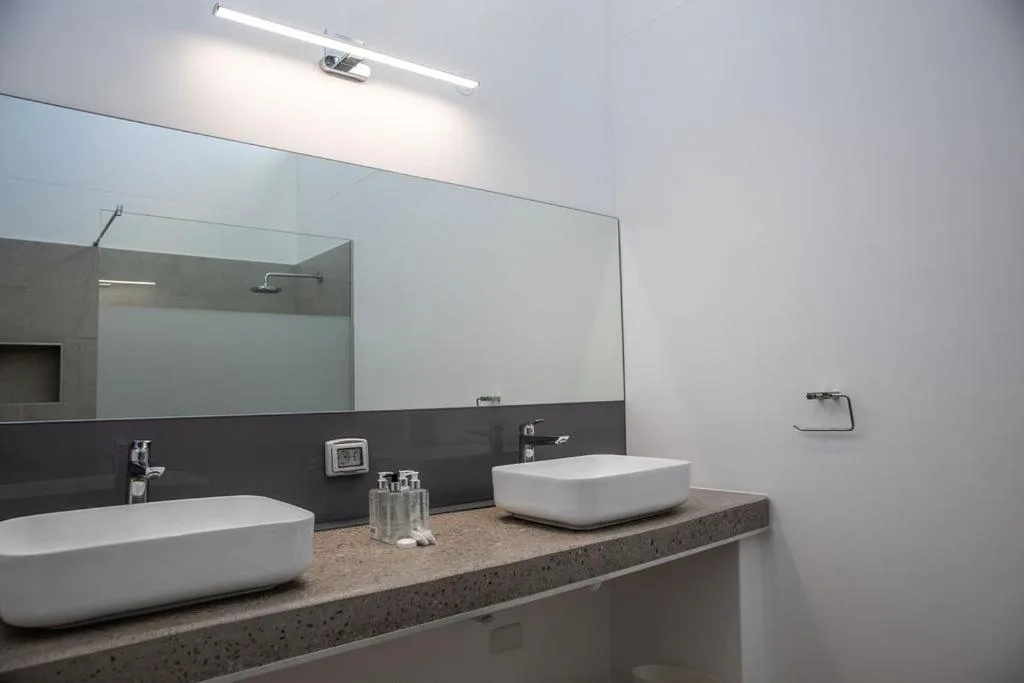 Modern bathroom with dual vessel sinks and large mirror
