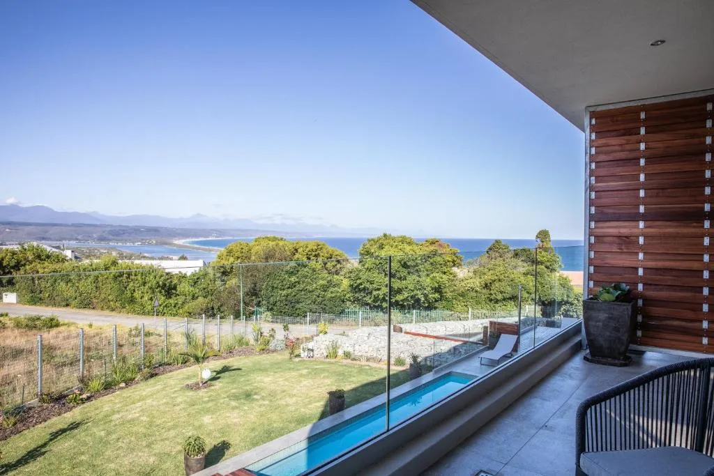 Panoramic coastal vista with mountains and blue ocean beyond property grounds