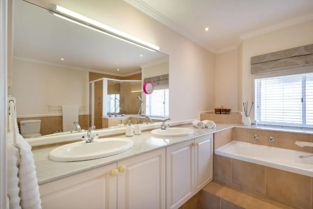 Spacious bathroom with dual vanity, soaking tub, and walk-in shower