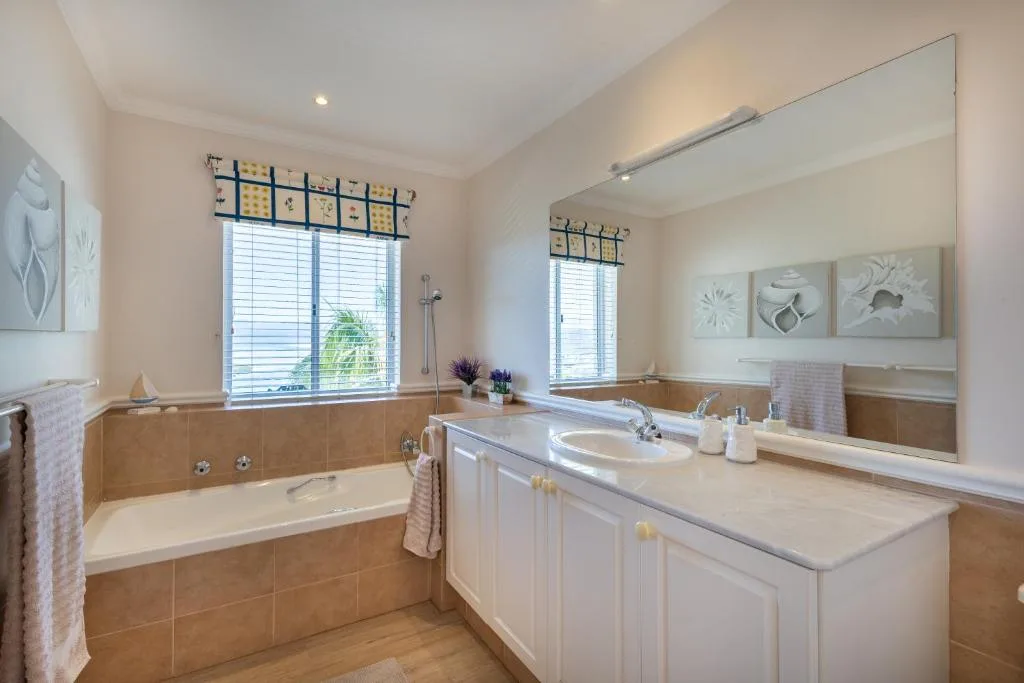 Spacious bathroom with bathtub, double vanity, and large mirror