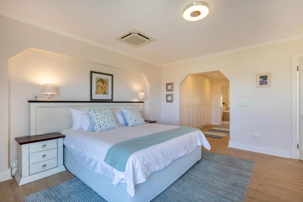 Spacious bedroom with queen bed, white headboard, and ensuite bathroom access
