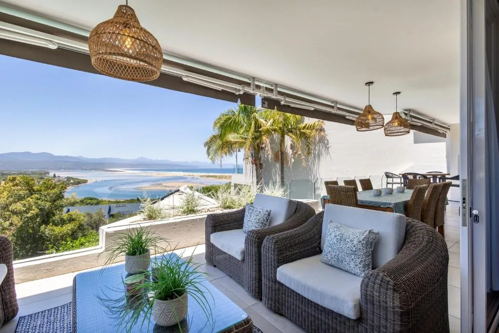 Covered outdoor deck with wicker seating and lagoon views