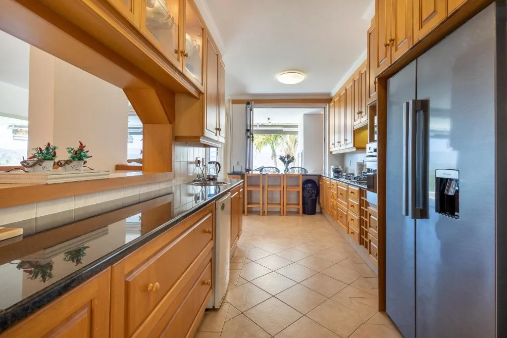 Spacious kitchen with wooden cabinetry, stainless steel appliances, and island seating