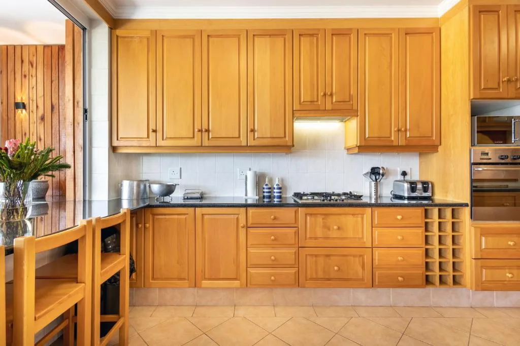 Spacious kitchen with golden wood cabinetry and stainless steel appliances