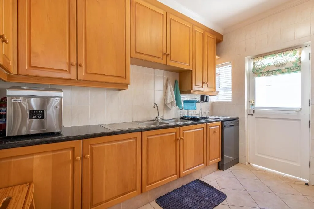 Spacious kitchen with wooden cabinetry, stainless steel appliances, and natural light