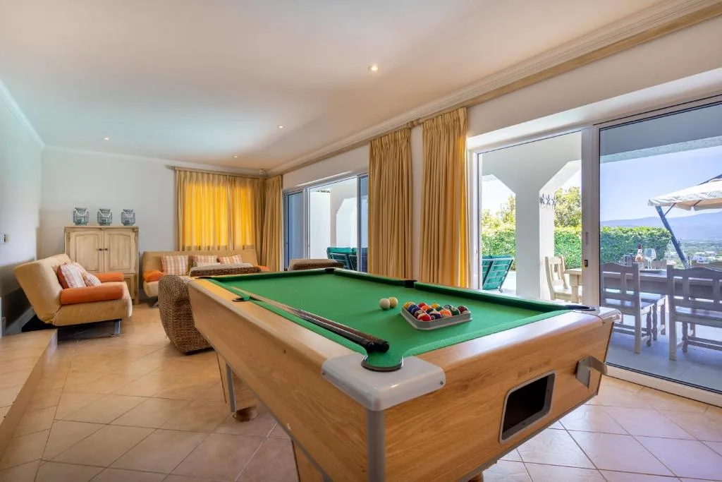 Modern lounge with pool table, comfortable seating, and scenic outdoor views