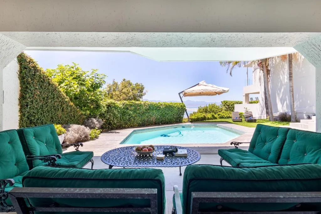 Swimming pool with lounge seating and garden views from covered deck