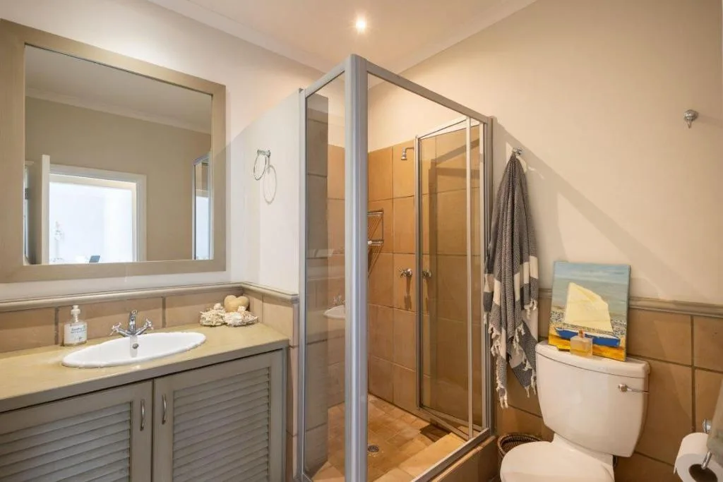 Modern bathroom with vanity sink, shower enclosure, and toilet