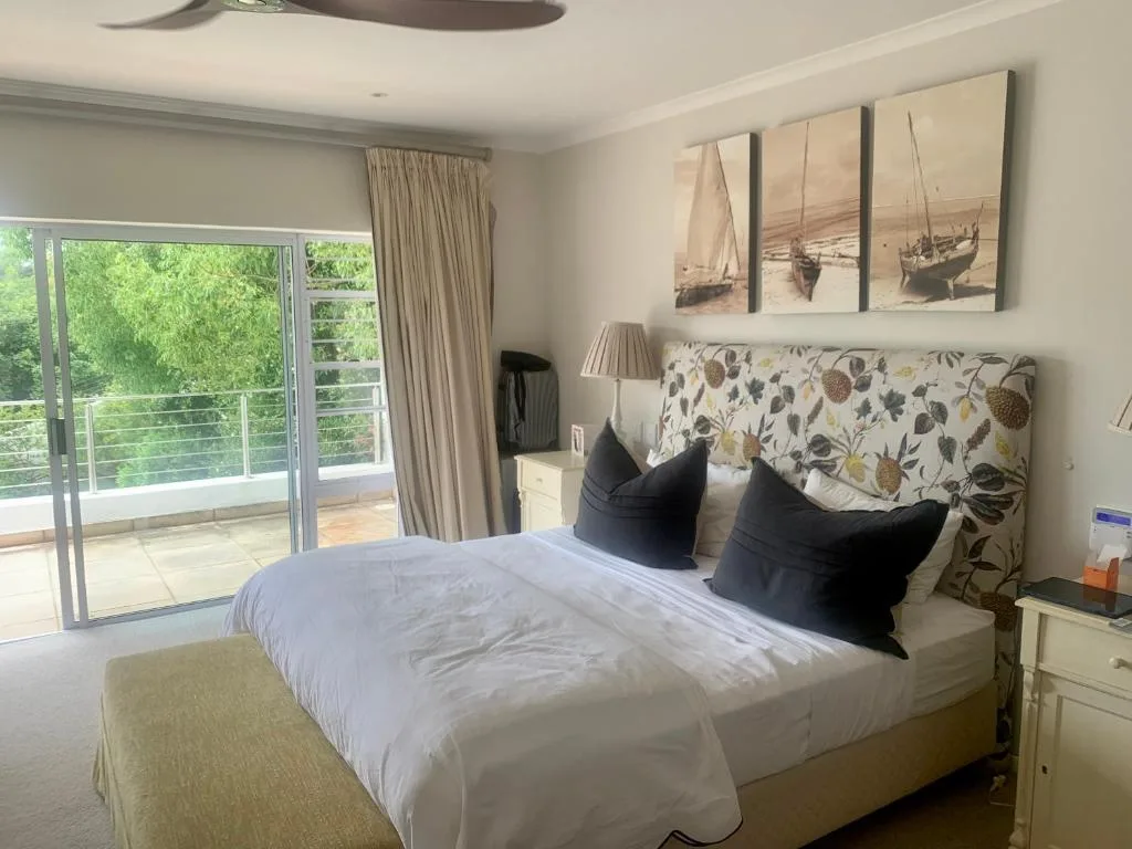 Bright bedroom with king bed, patterned headboard, and balcony access