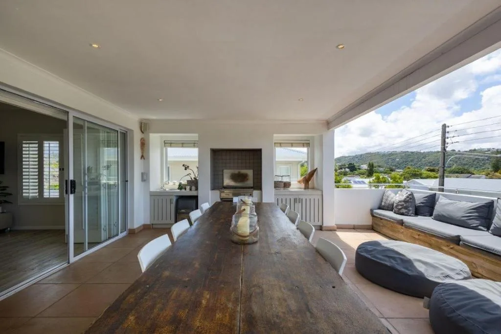 Expansive covered terrace with dining table and lagoon views