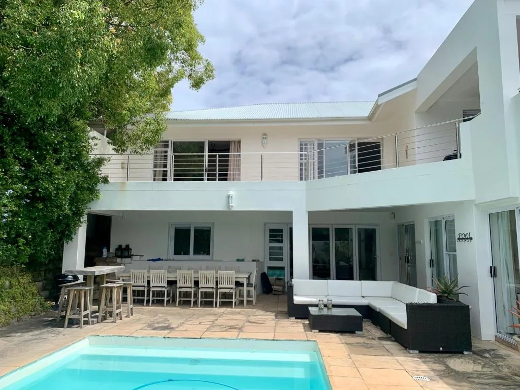 Spacious patio with dining table, lounge seating, and pool area