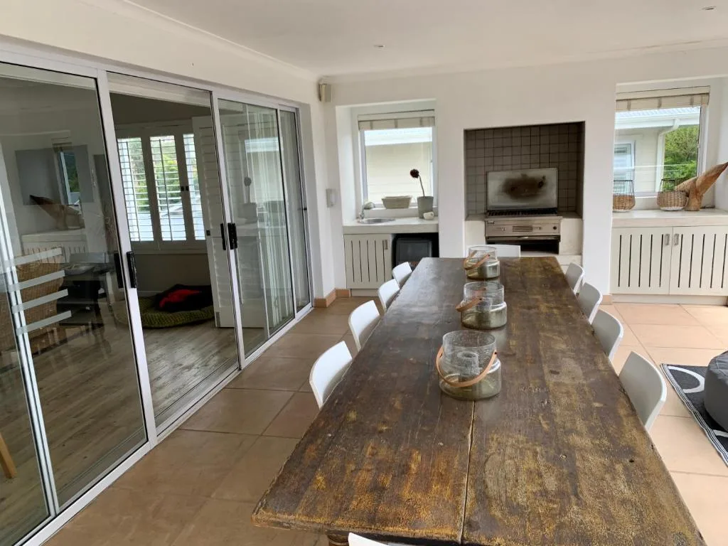 Spacious dining area with rustic wooden table and white chairs