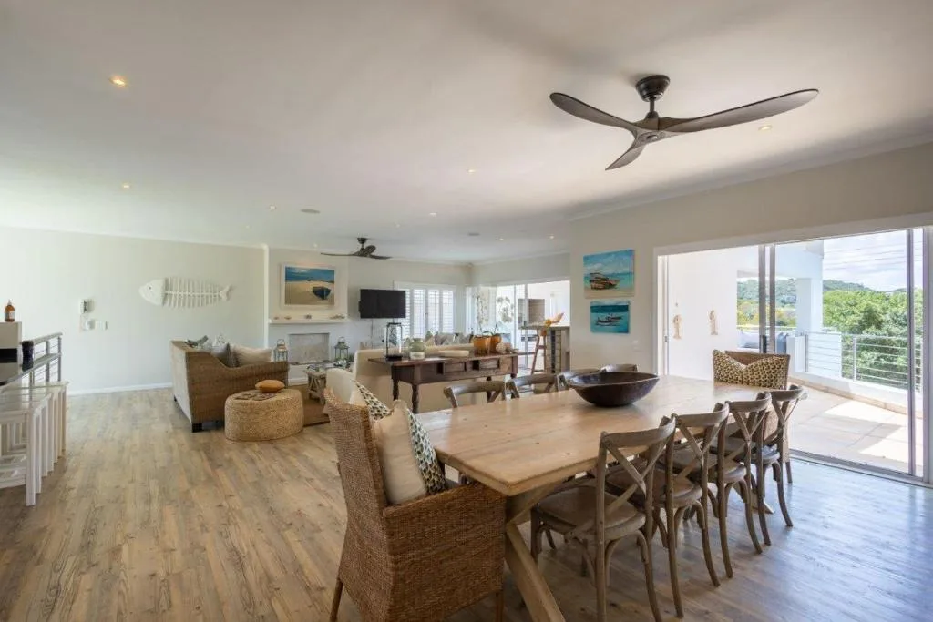 Open-plan lounge and dining area with coastal views and modern furnishings