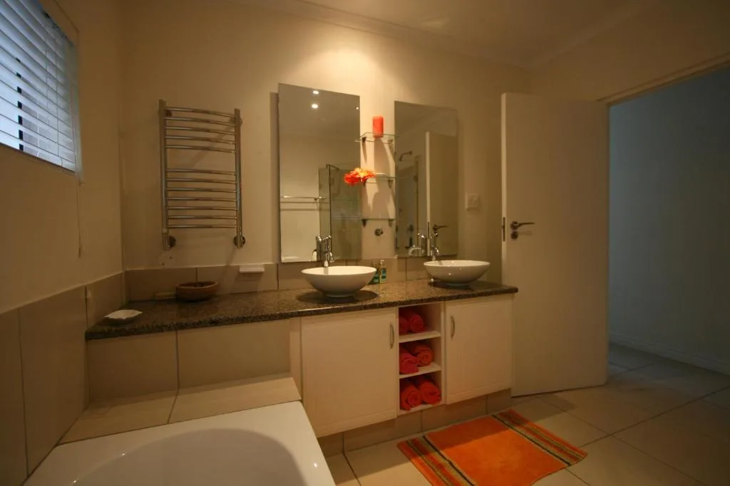 Spacious bathroom with double vanity sinks and large mirrors overhead