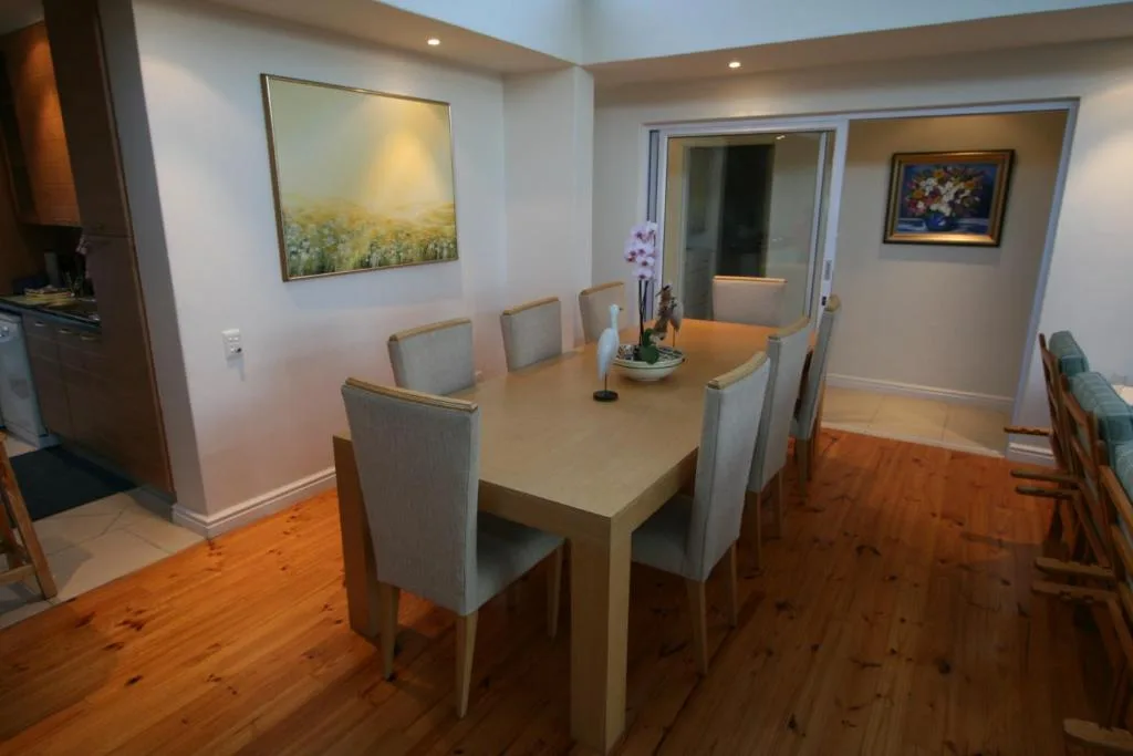 Modern dining room with wooden table and six upholstered chairs