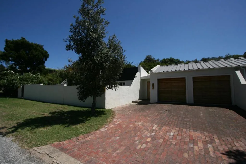 Modern white house with brick driveway and manicured gardens