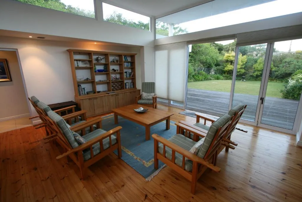 Spacious lounge with wooden furniture and large windows overlooking gardens