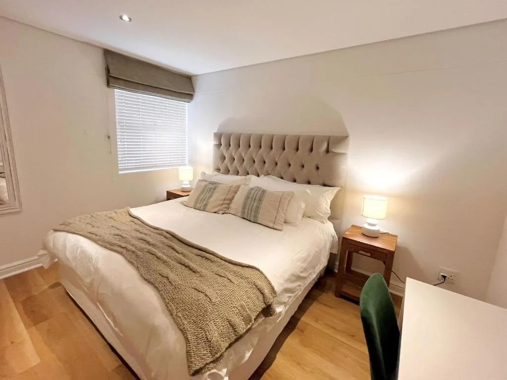 Spacious bedroom with upholstered headboard and white bedding