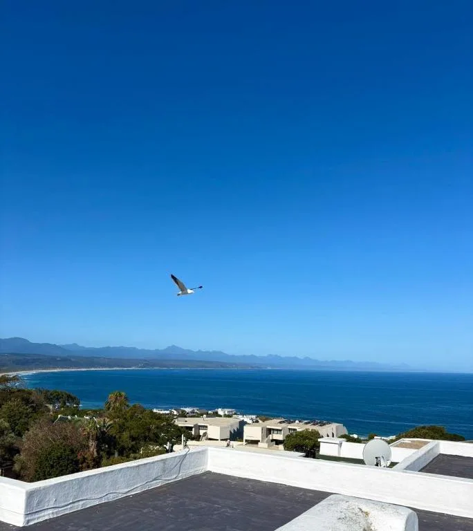Panoramic coastal view with mountains and blue ocean from property deck