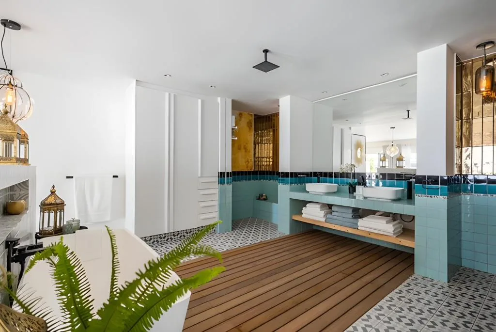 Modern bathroom with turquoise tiles, dual vanities, and walk-in shower
