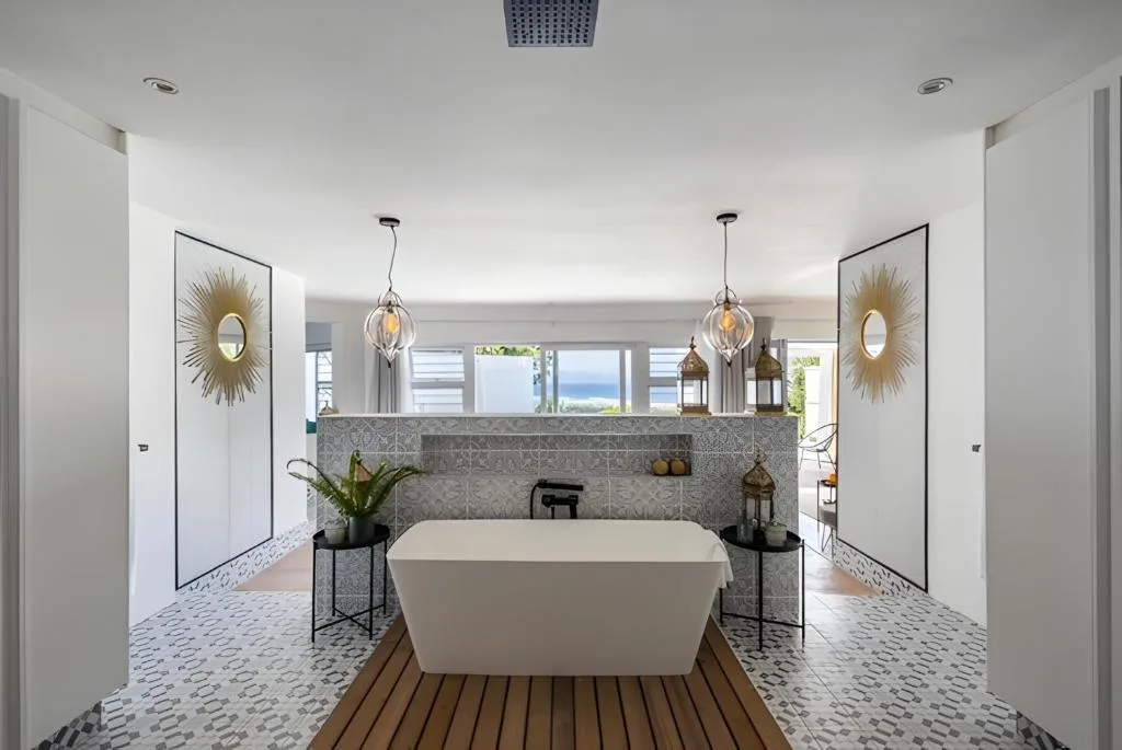 Luxury spa bathroom with freestanding tub, pendant lights, and ocean views
