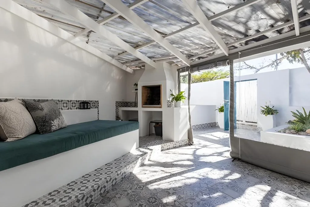 Covered outdoor patio with built-in seating, pergola, and garden views